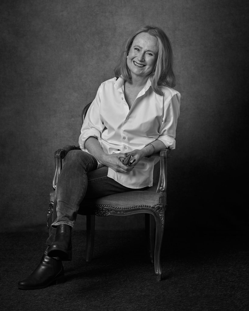 Porträtt av kvinna som sitter på en stol fotograferat i studio i Göteborg